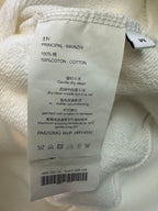 Clothing care label inside white sweatshirt: 100% cotton, dry clean