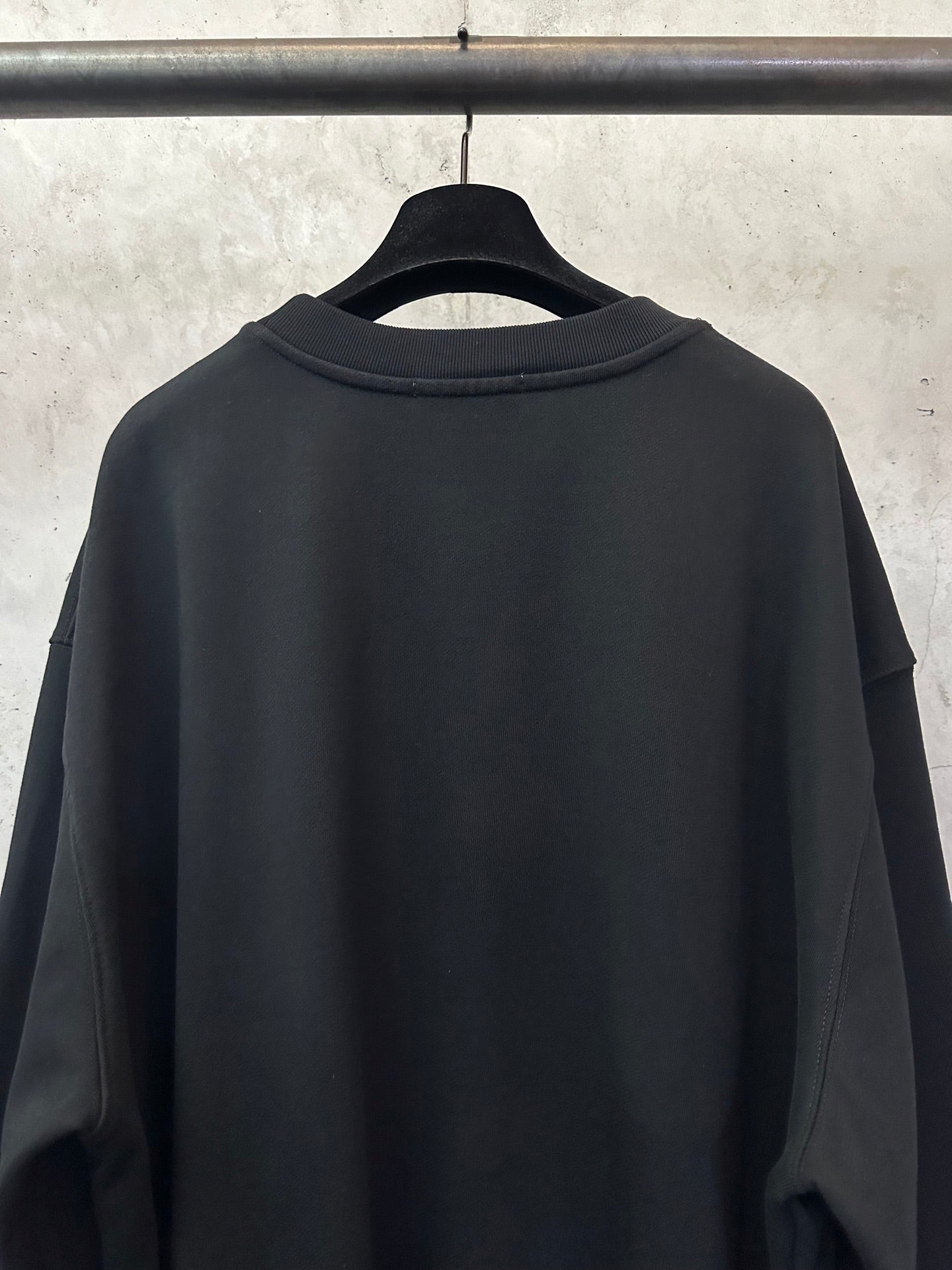 Black sweatshirt back view with ribbed crew neck and long sleeves