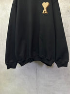 Black sweatshirt with gold A heart logo near the upper chest, long sleeves and ribbed hem