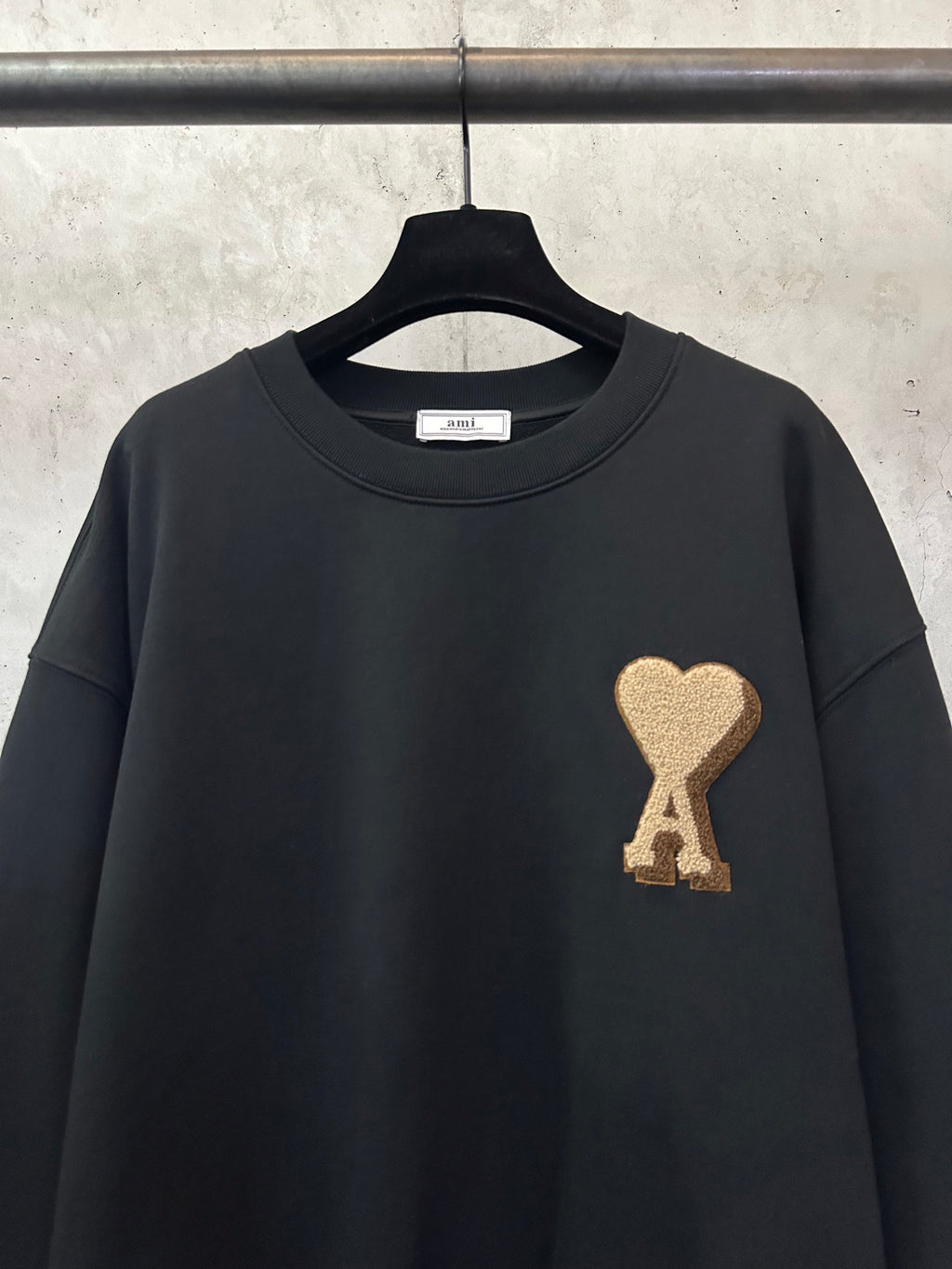 Black sweatshirt with gold A heart logo on chest, crew neck and short round collar