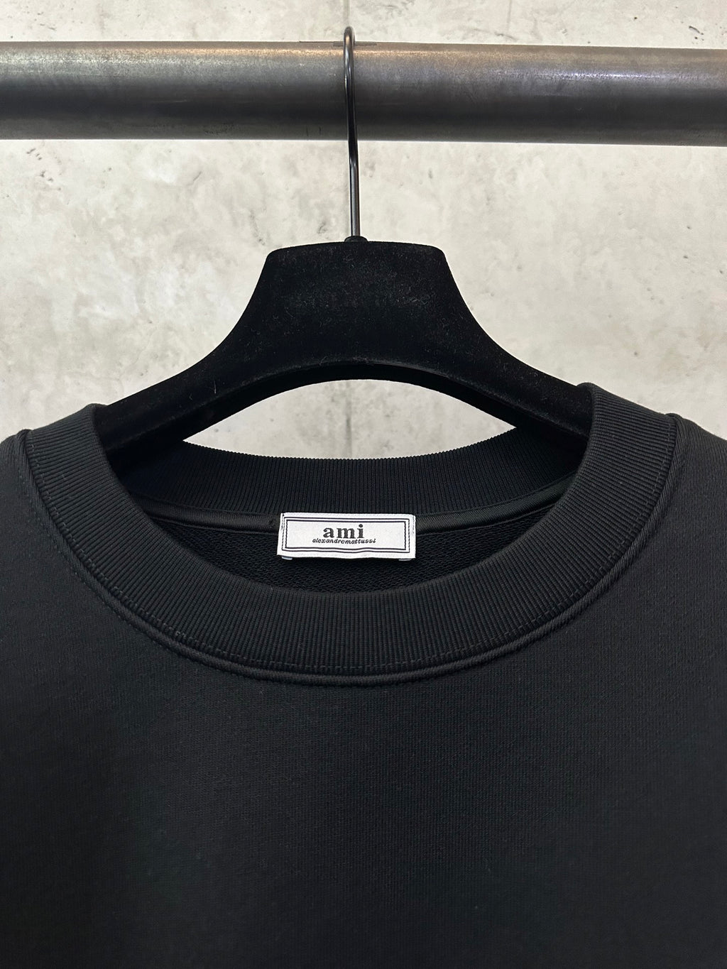 Black sweatshirt close-up of crew neckline with inner brand label