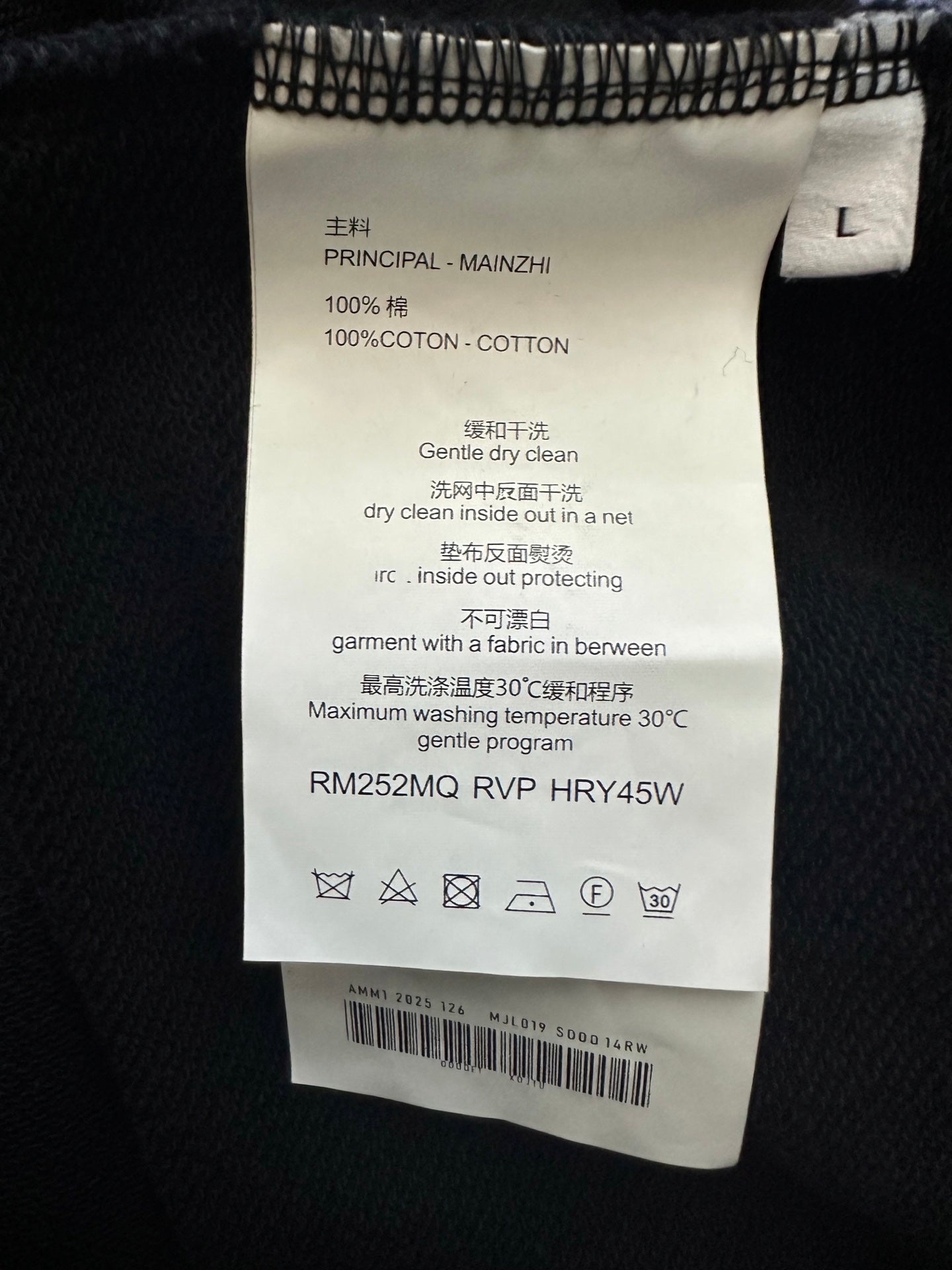 Size and care label inside black sweatshirt, 100% cotton and cleaning instructions