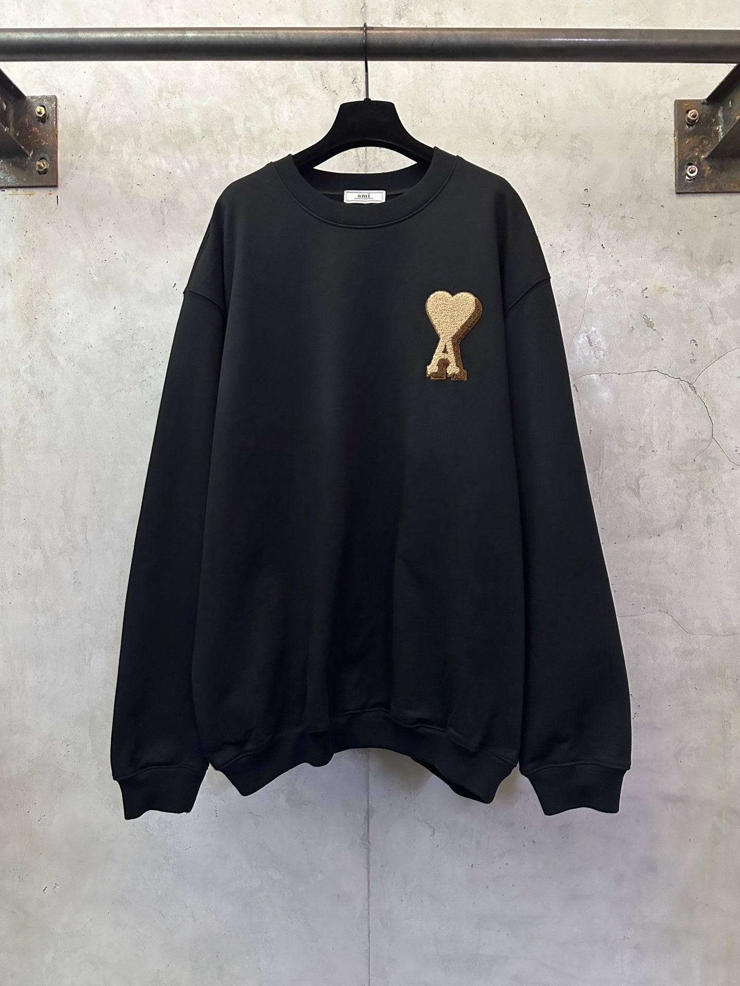 Black sweatshirt with gold A heart logo on front, crew neck and long sleeves