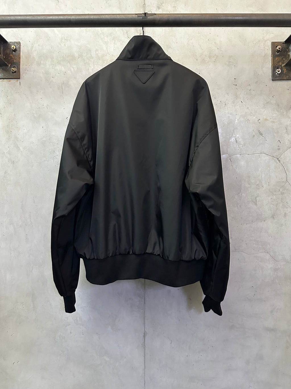 Black back view bomber jacket with stand collar and ribbed hem