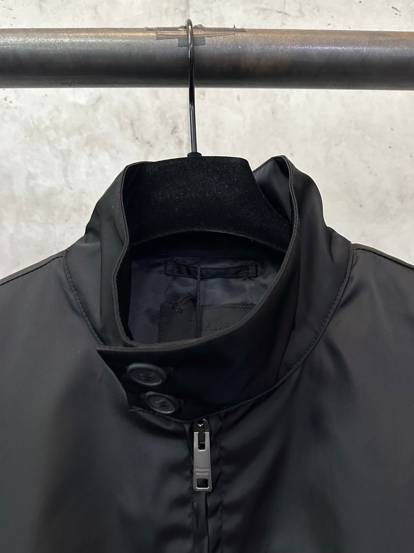 Black jacket collar and center zipper with inner lining visible at neckline
