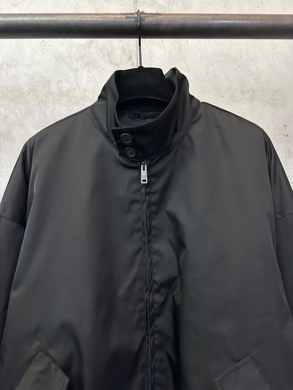 Black stand-collar jacket with center zip and snapped placket detail