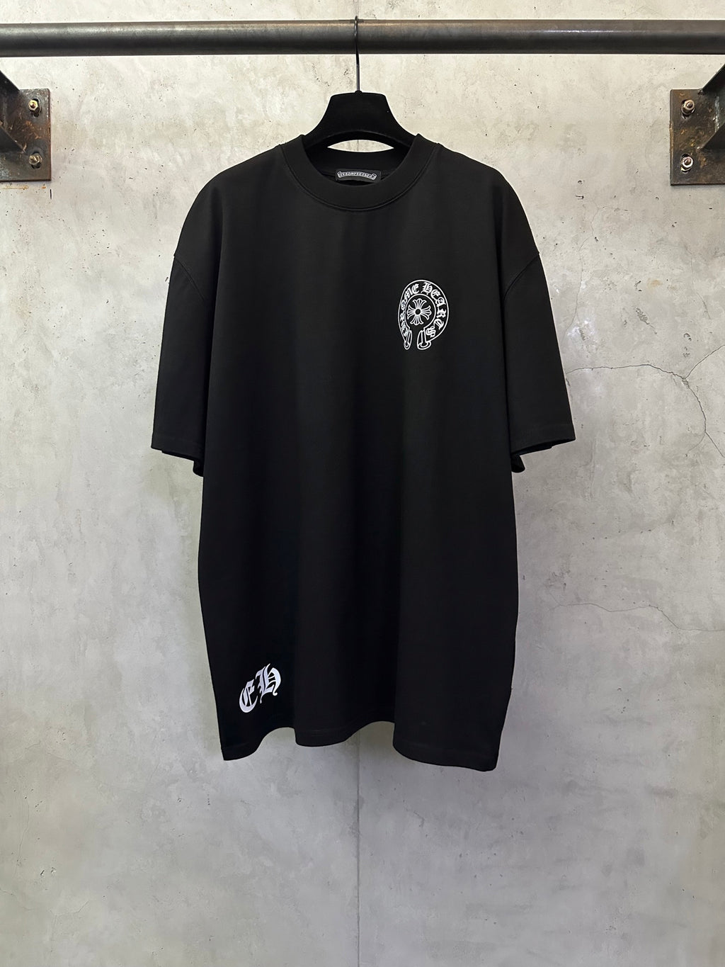 Black short-sleeve T-shirt with small circular chest graphic and crew neck