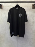 Black short-sleeve T-shirt with small circular chest graphic and crew neck