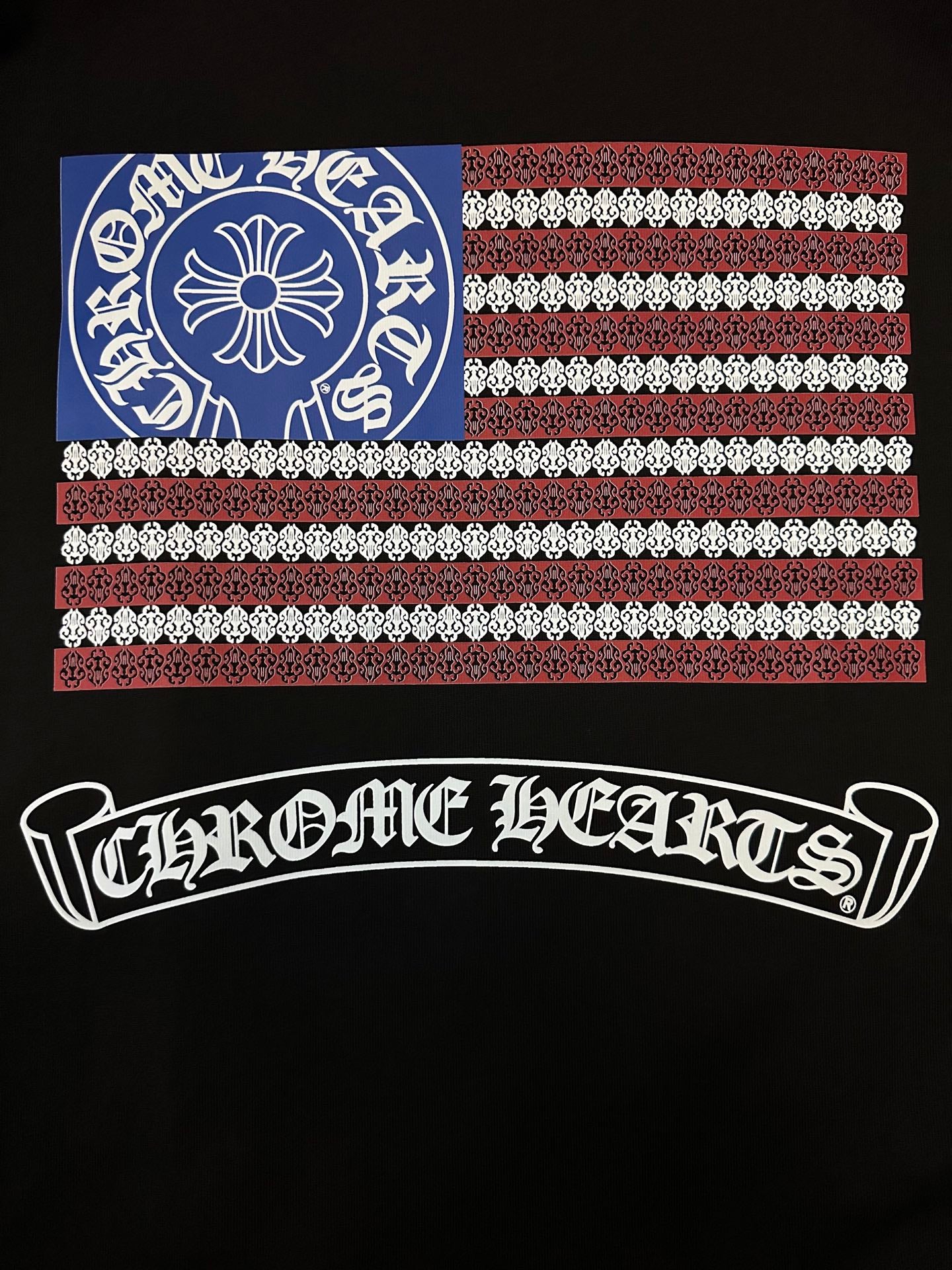 Black short-sleeve T-shirt close-up of back graphic: flag panel and arched logo