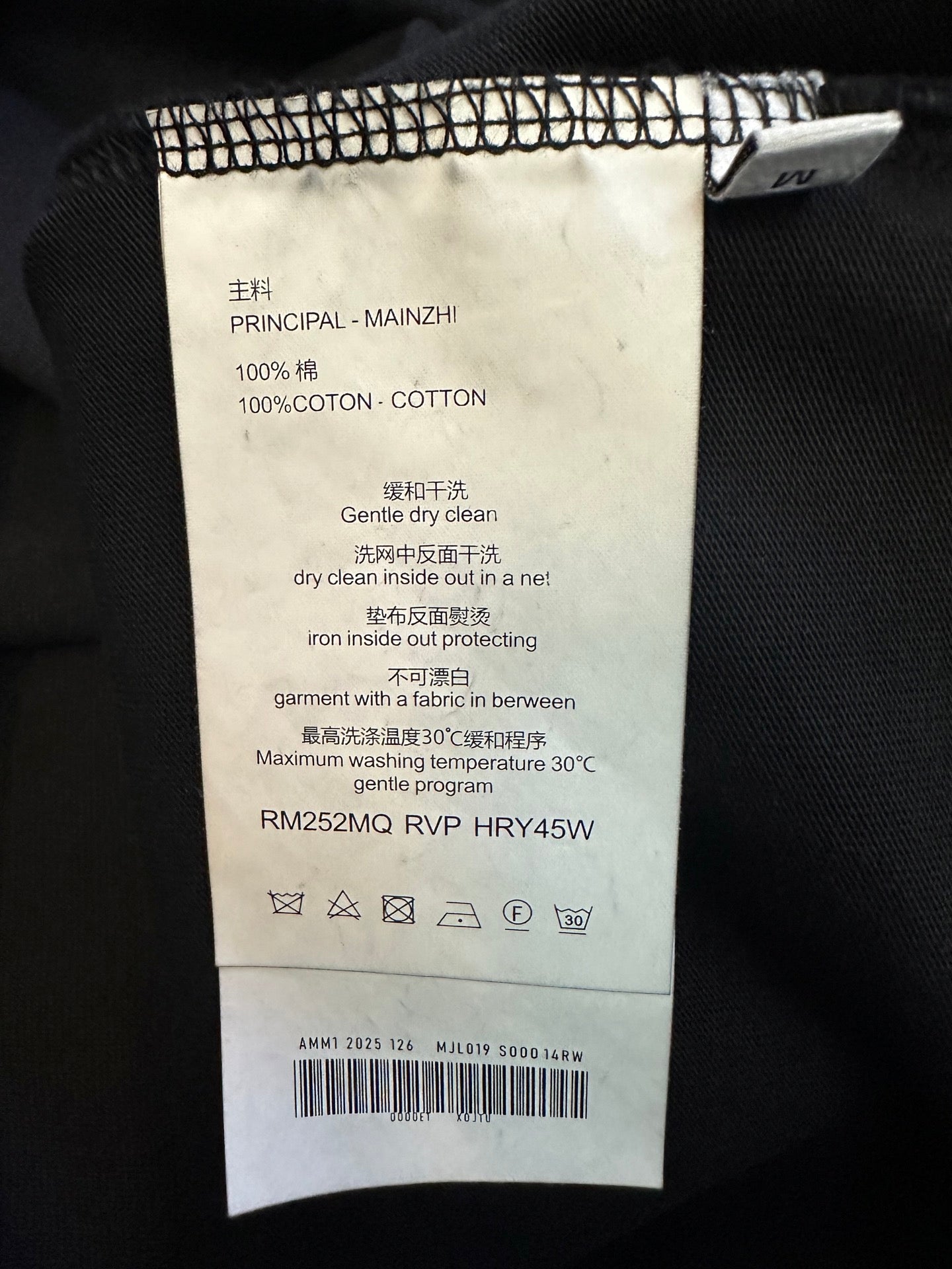 T-shirt care label with cotton and washing instructions inside neck seam