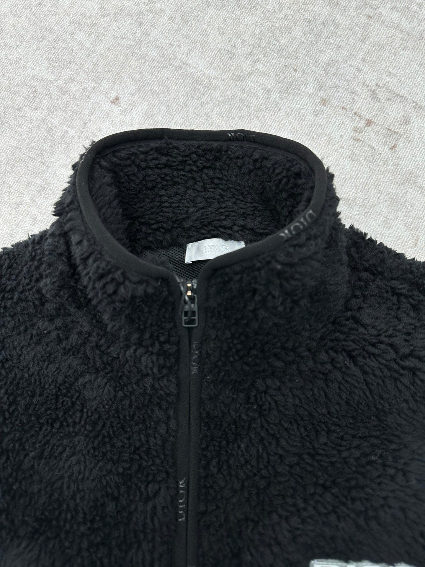 Dior black sherpa jacket close-up with front zipper and stand collar
