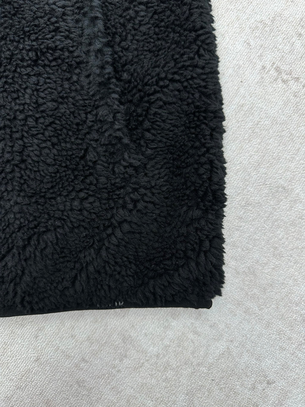 Dior black sherpa jacket hem close-up with curly textured fabric