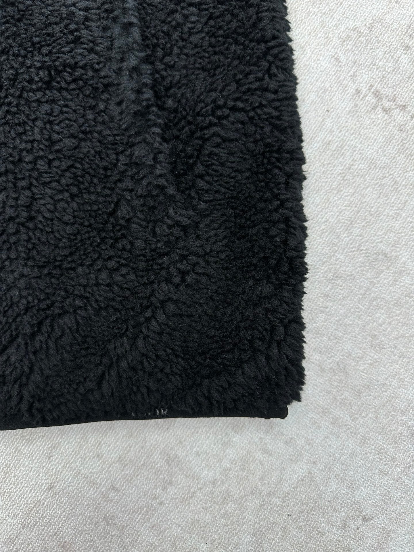 Dior black sherpa jacket hem close-up with curly textured fabric