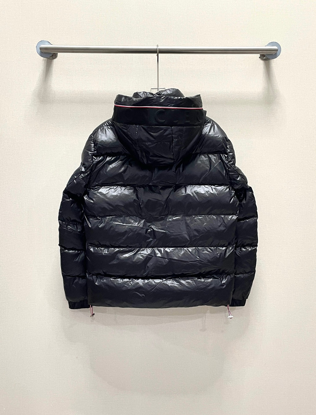 Moncler long puffer jacket, dark color back view with hood, on hanger