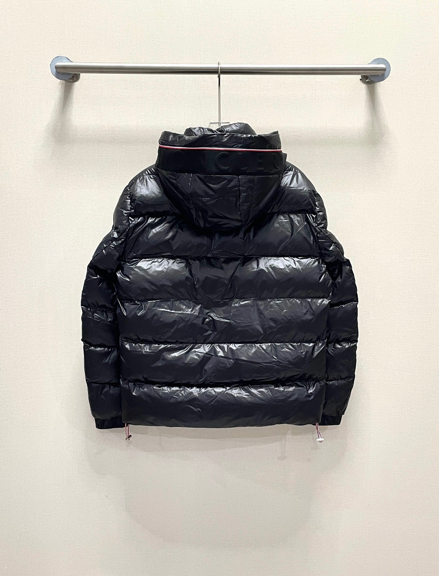 Moncler long puffer jacket, dark color back view with hood, on hanger
