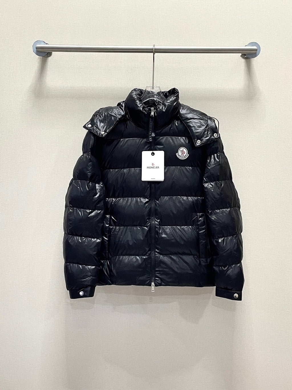 Moncler long puffer jacket, dark color front view on hanger with logo patch
