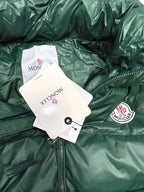Dark green puffer jacket close-up with front zipper and circular chest logo patch