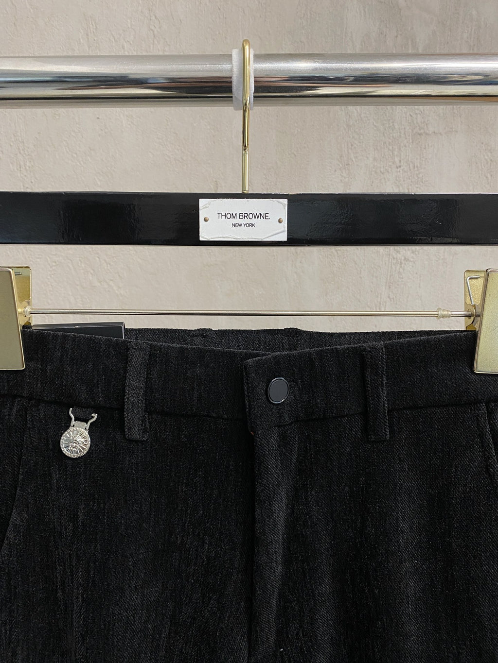 Black trousers waistband with belt loops and center button closure