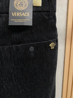 Black Versace trousers with front button and small gold side logo