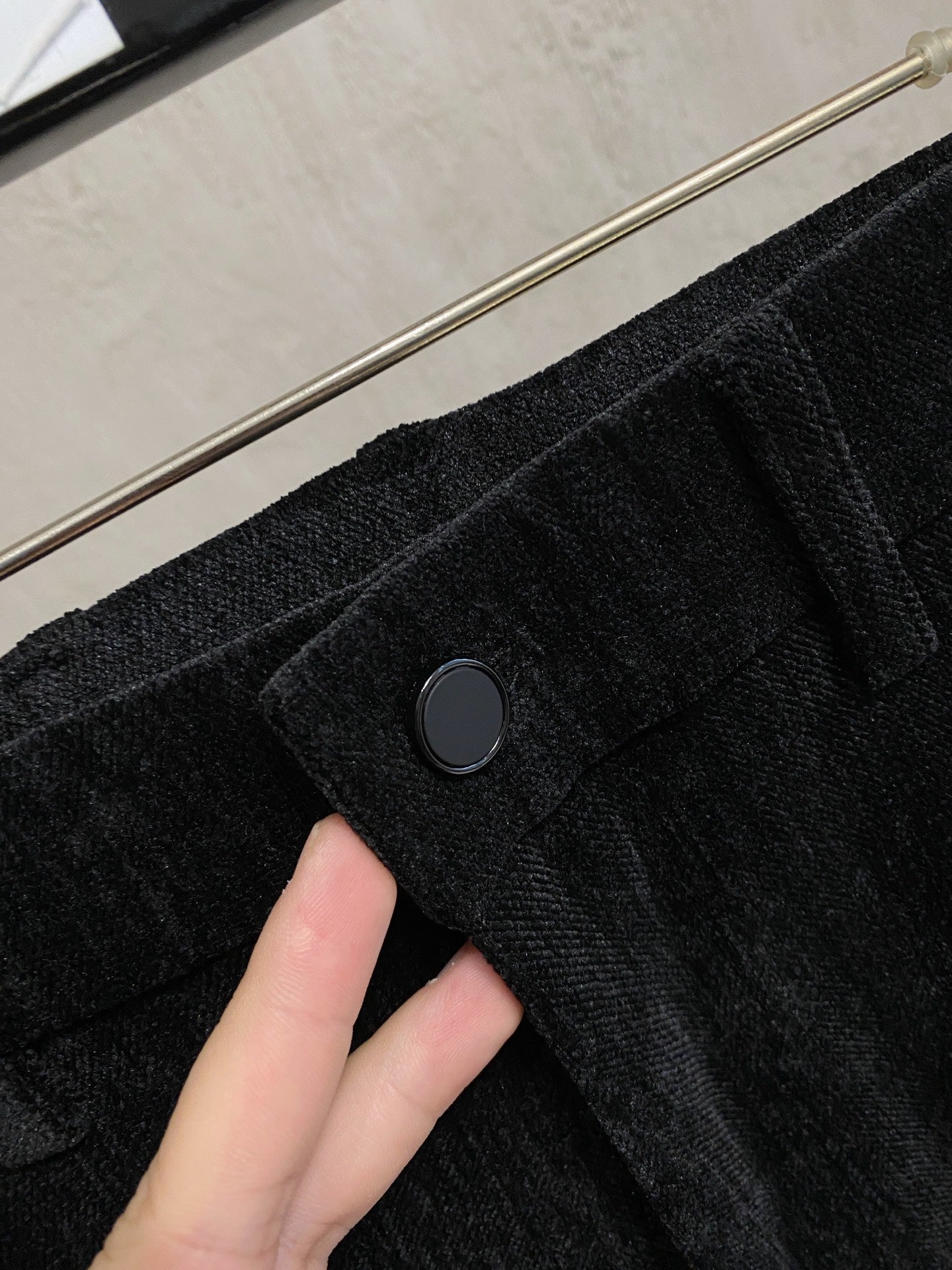 Black trousers close-up of front button and waistband seam