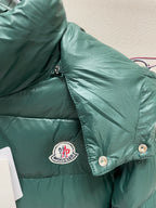 Dark green puffer jacket close-up with chest logo patch and snap button placket
