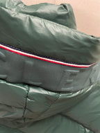 Dark green puffer jacket shoulder with red-and-blue trim stripe detail