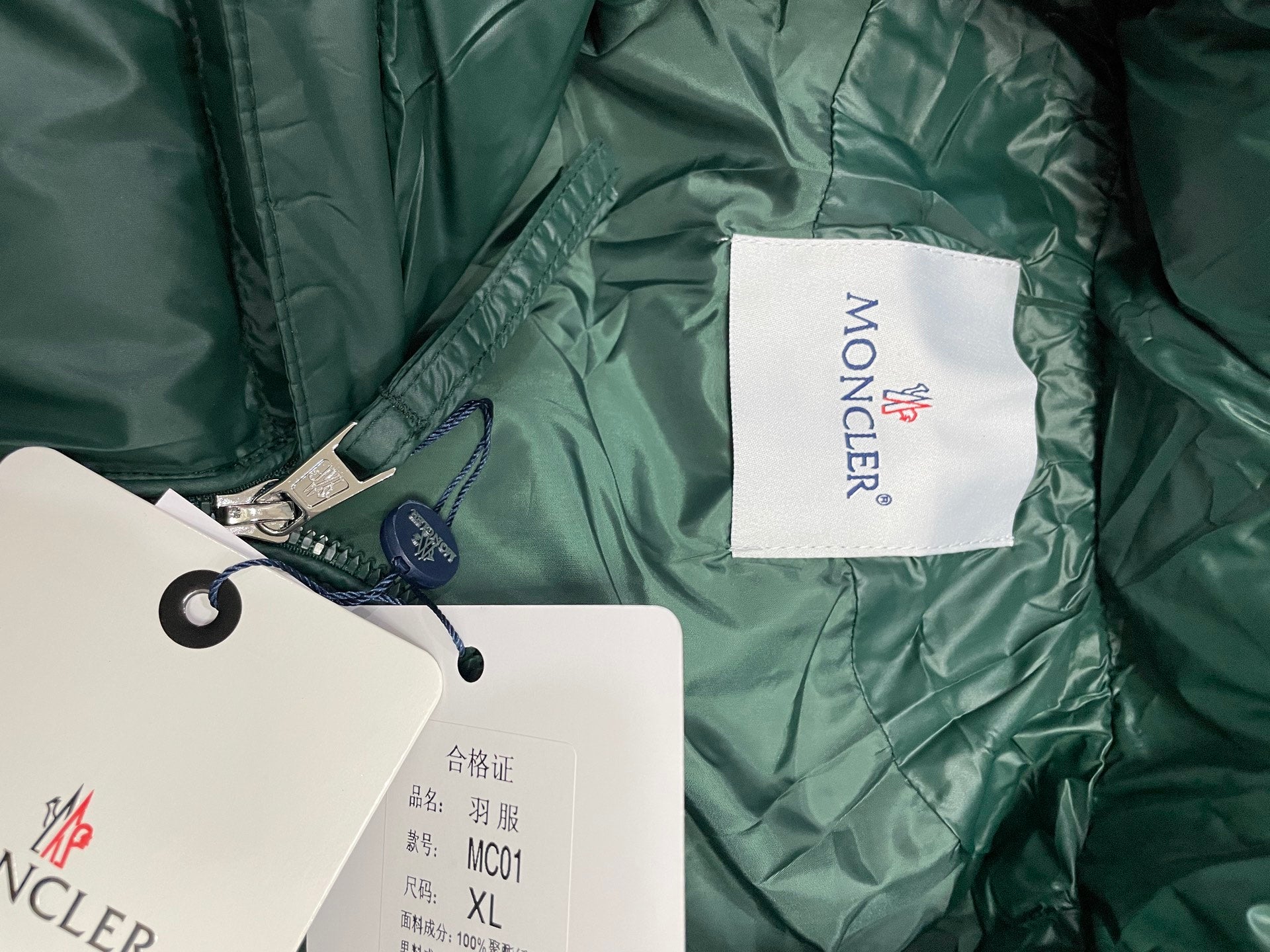 Dark green puffer jacket interior lining with white size label tag