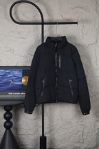 Moncler long black puffer jacket with front zipper and stand collar, hanging on hanger