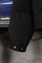 Black puffer jacket sleeve cuff with snap buttons and ribbed trim