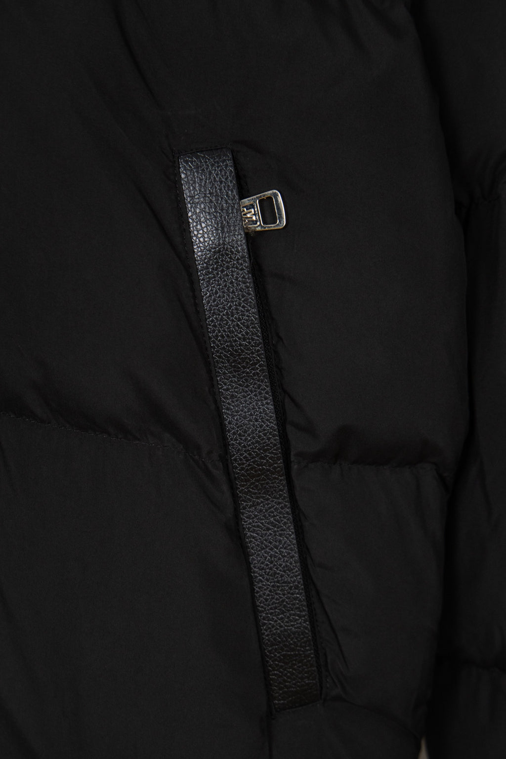 Black puffer jacket front with zipper and metal slider on textured placket