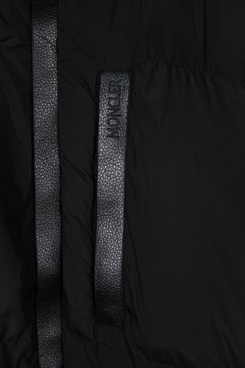 Black puffer jacket center placket with vertical textured label detail