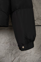 Black puffer jacket lower sleeve with cuff snaps and gathered hem opening