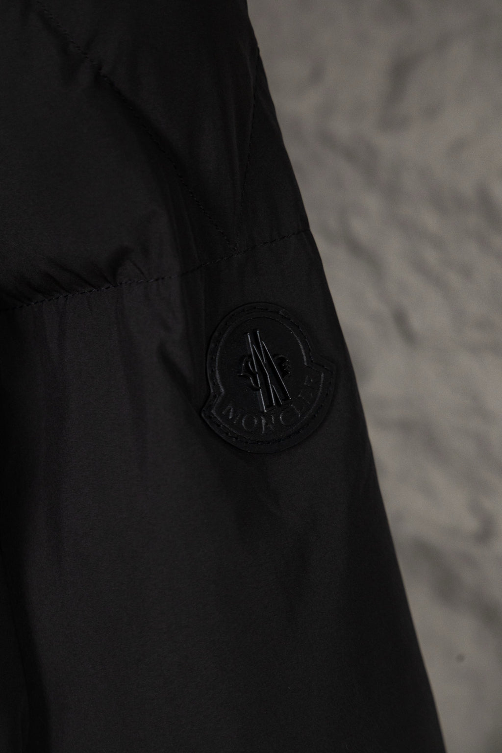 Long black Moncler jacket with circular logo patch