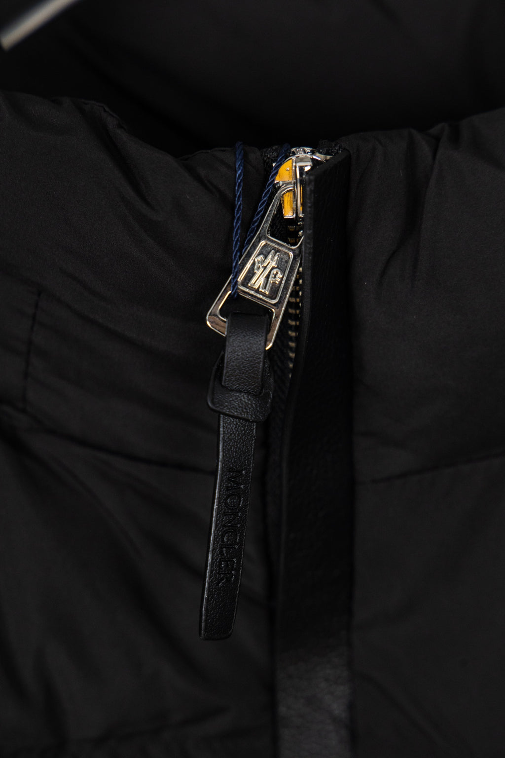 Black puffer jacket zipper and metal pull hardware with textured trim
