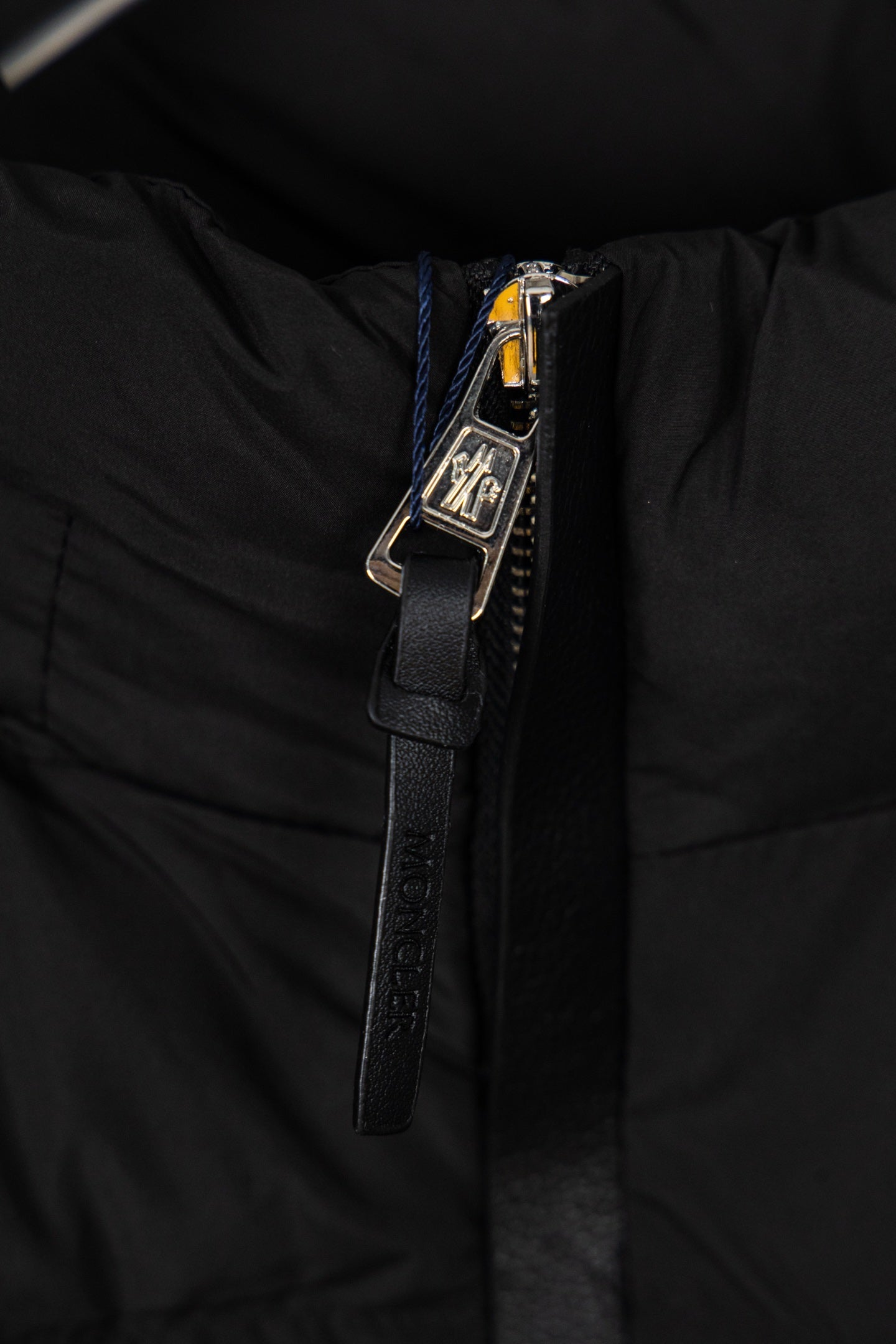 Black puffer jacket zipper and metal pull hardware with textured trim