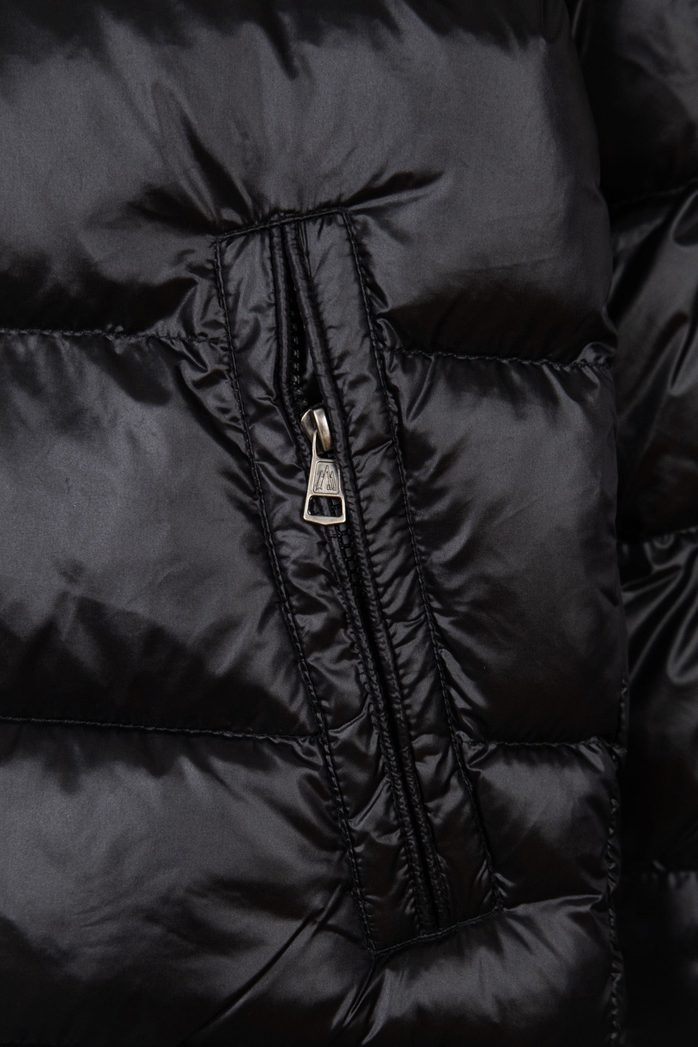 Moncler puffer jacket zipper close-up in dark fabric