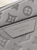 Louis Vuitton gray leather bag close-up with embossed monogram pattern and zipper trim