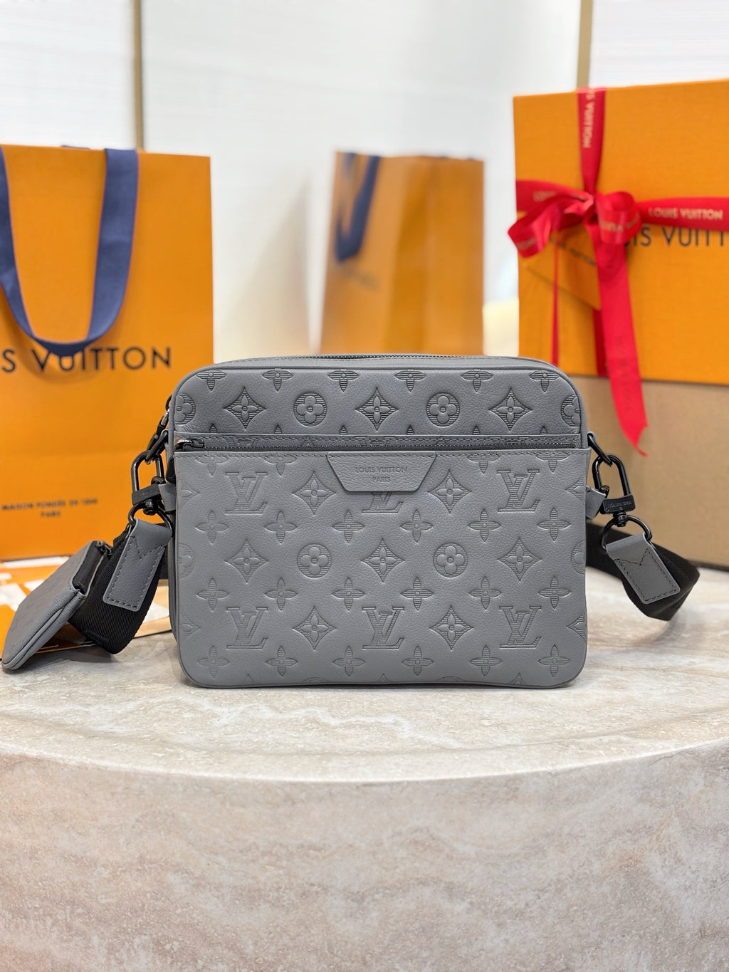 Louis Vuitton embossed monogram crossbody bag in gray with top zipper and logo front