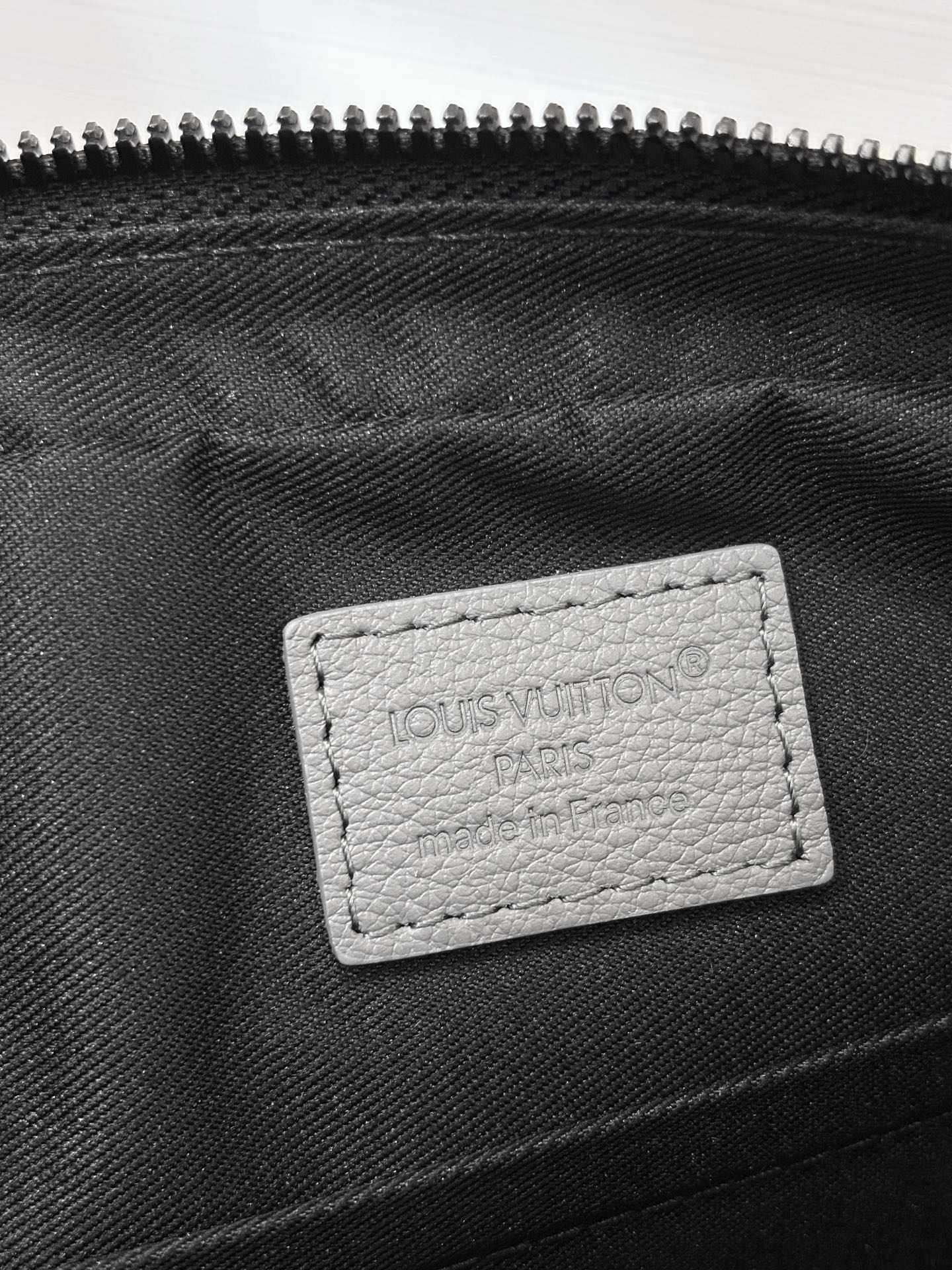 Louis Vuitton interior label on black lining inside zippered crossbody bag