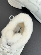 White fur-lined Chanel sneaker with logo detail at the tongue