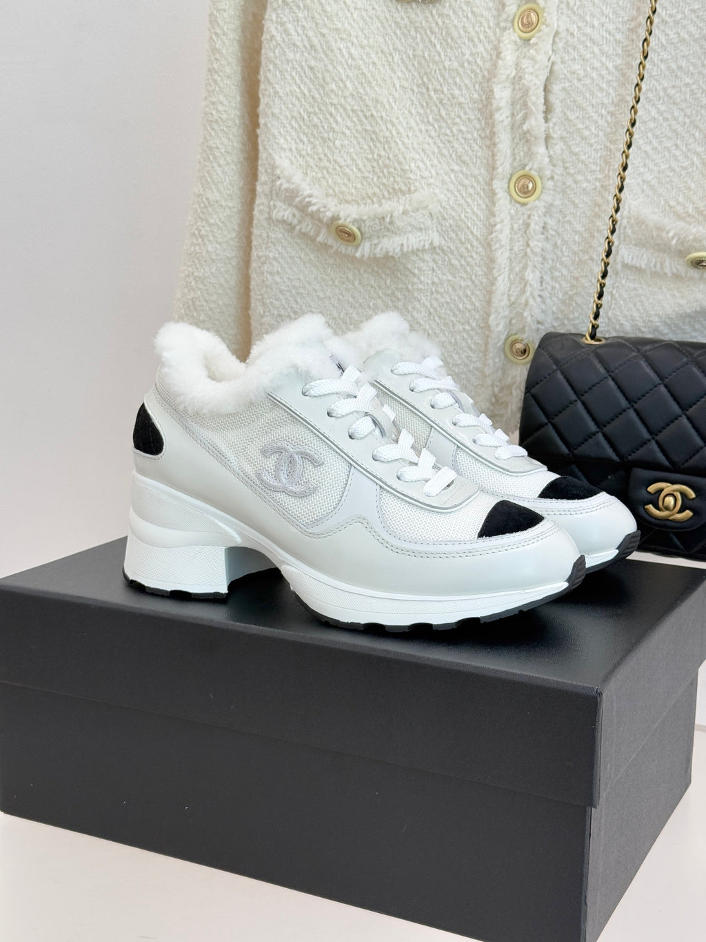 White leather-style sneakers with black side panels and white laces