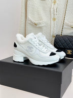 White leather-style sneakers with black side panels and white laces