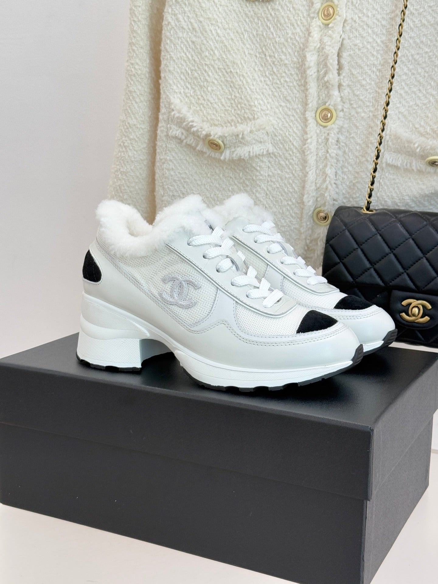 White leather-style sneakers with black side panels and white laces