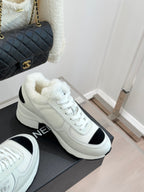 White chunky sneakers with black heel/side inserts and white lace-up design