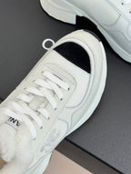 White sneaker showing lace-up front with black interior side panel