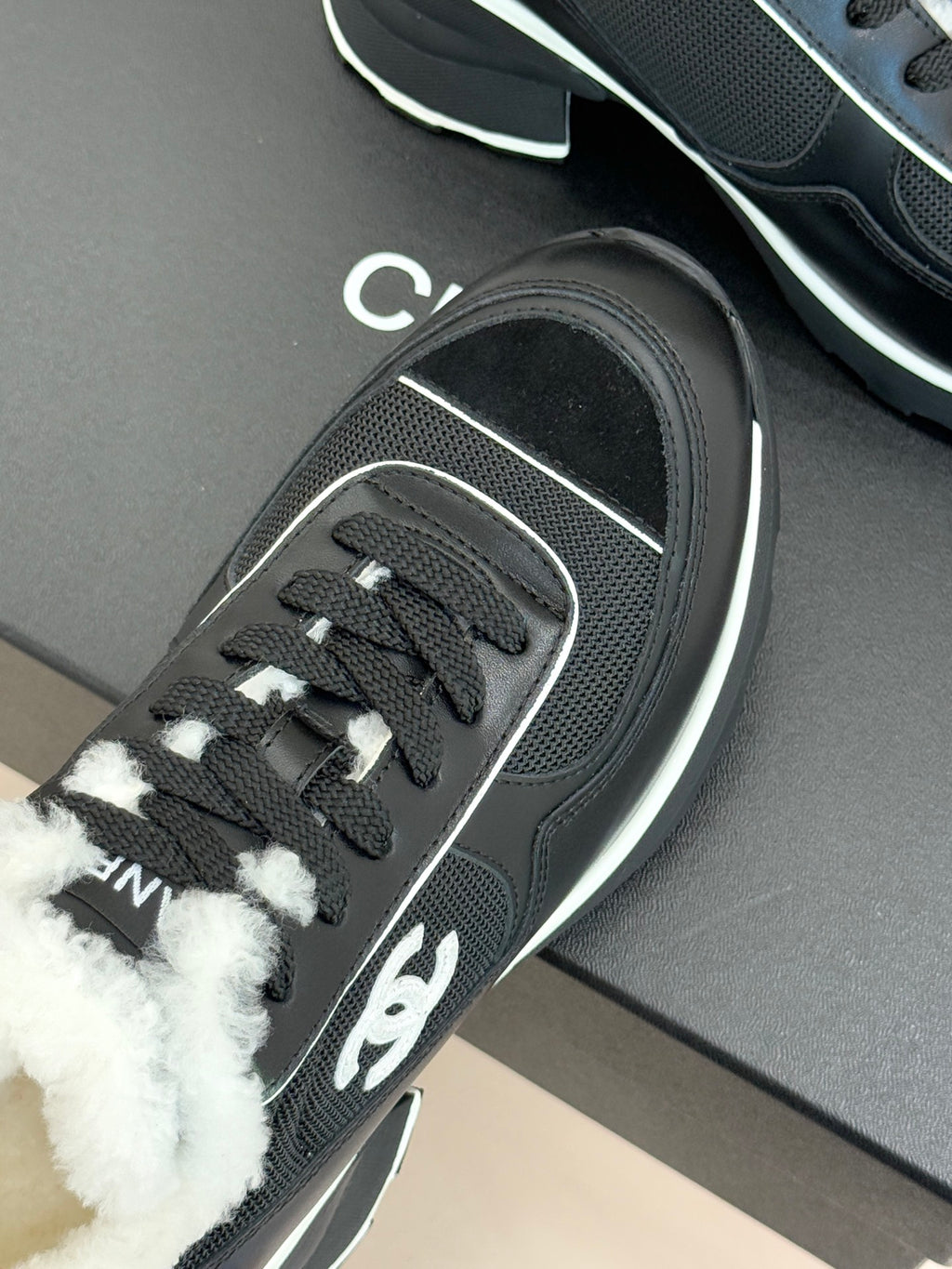 Chanel ladies sneakers side view, black mesh with white trim and lace-up