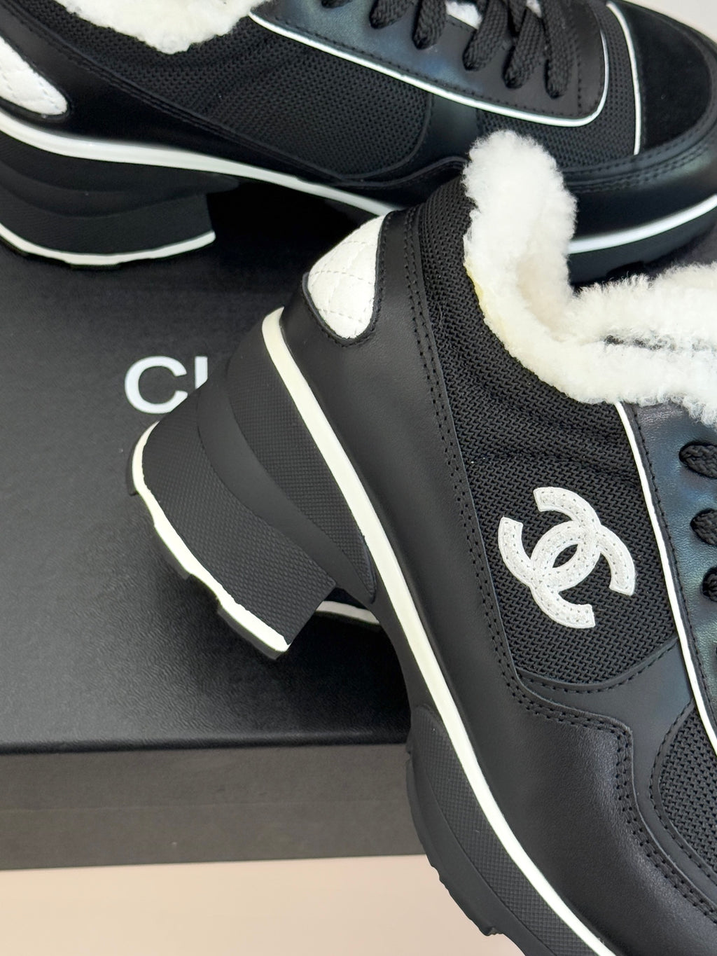 Chanel ladies sneaker close-up, black upper with white-trim logo detail