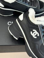 Chanel ladies sneaker close-up, black upper with white-trim logo detail