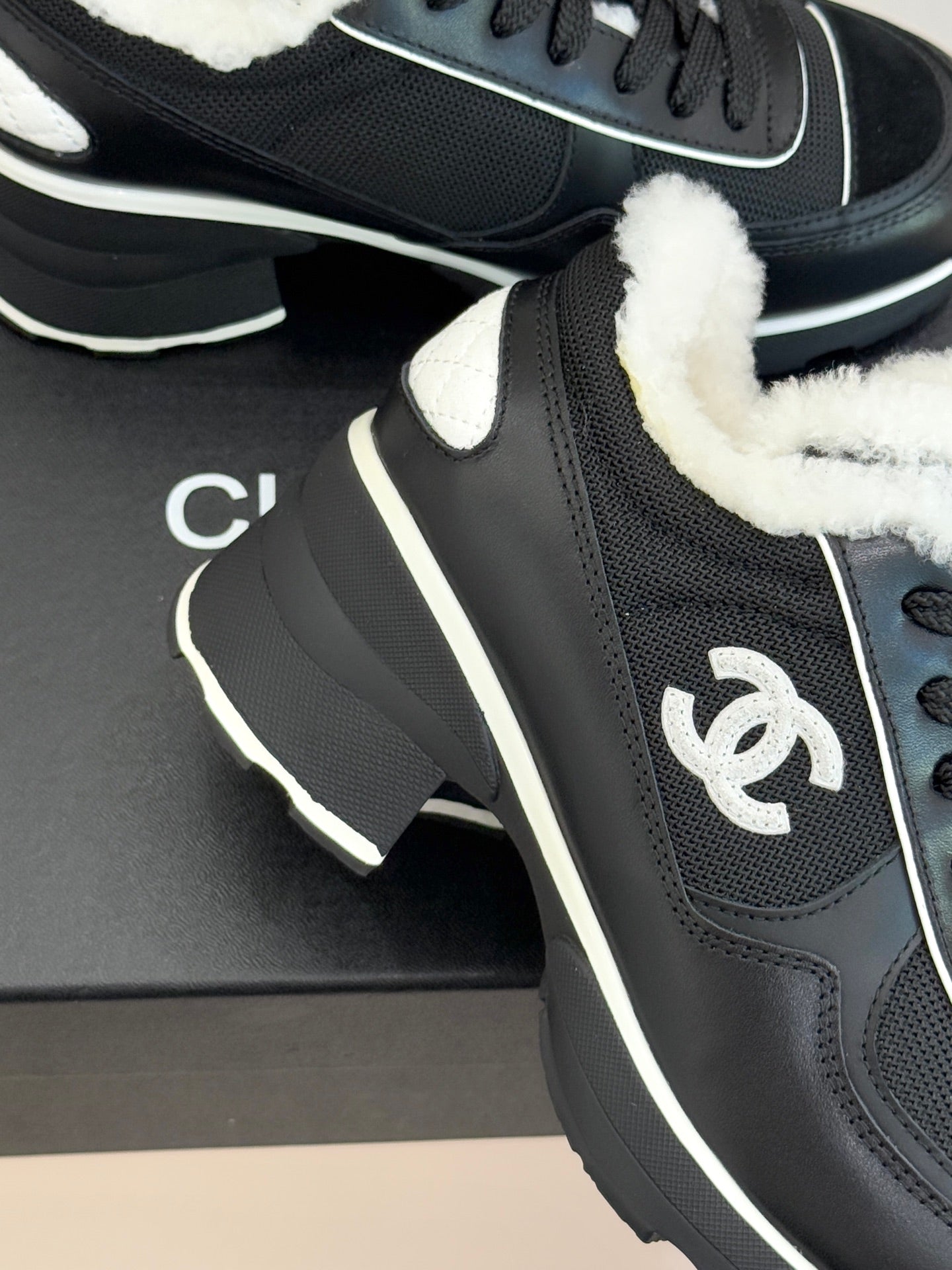 Chanel ladies sneaker close-up, black upper with white-trim logo detail