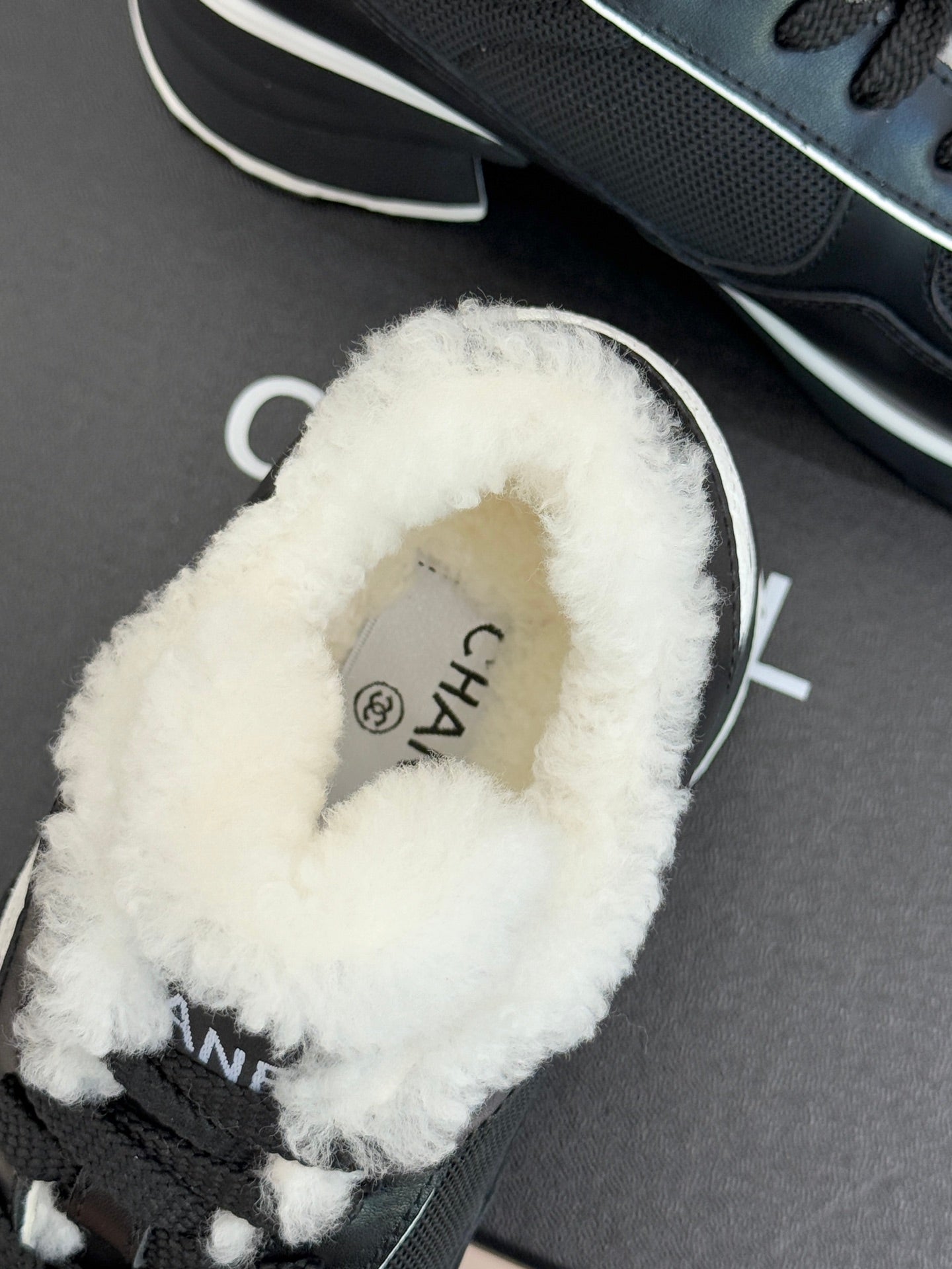 Chanel ladies sneaker interior close-up, plush white lining and sock-like fit
